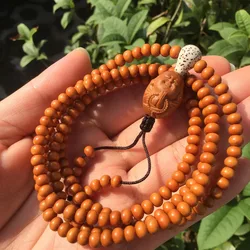 A - apple pendant necklace, paired with an olive-pit carving symbolizing devotion to Buddha