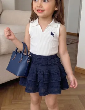 Conjunto de 2 piezas para niñas de estilo casual universitario, top sin mangas con cuello polo y bordado de pony, y falda de volantes multicapa tipo - Shein - FashionsVida