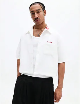 Camisa de manga corta con botones y detalle de logotipo bordado en el pecho, ajuste regular, casual de verano y primavera, lisa para el Día de San Va - Shein - FashionsVida