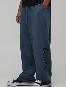 Herren Jogginghose Mit Ballonschnitt, Kontrastnähten Und Kalifornien-Aufdruck In Loopback-Qualität Slate Blue Größe XS - boohooMAN - FashionsVida