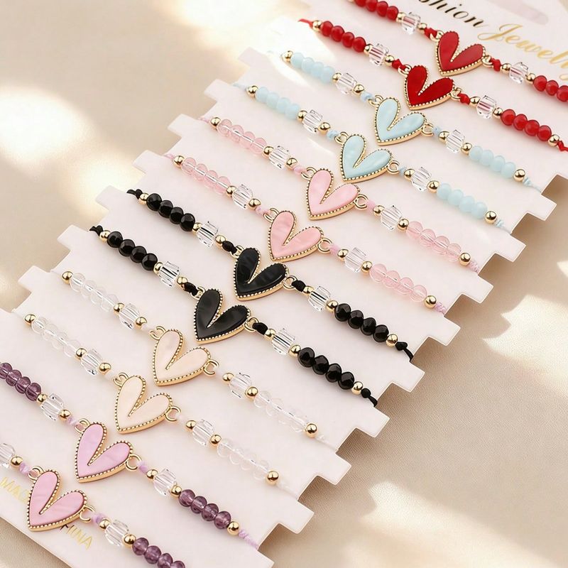 Este conjunto de pulseras multipieza con forma de corazón presenta cuerda tejida a mano y colgantes con forma de corazón, convirtiéndolo en la opci